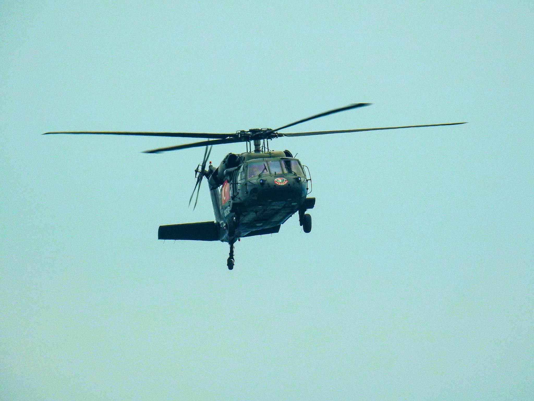 A military helicopter flying through a clear sky, showcasing aviation technology.